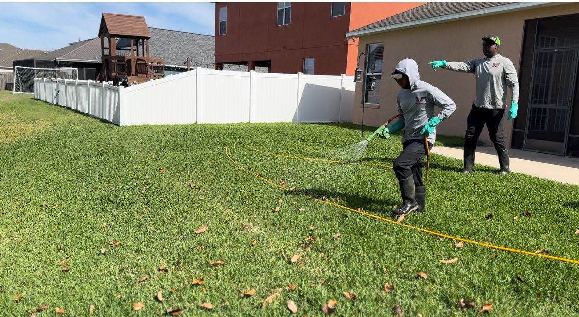 Two men are spraying a lawn with a hose.