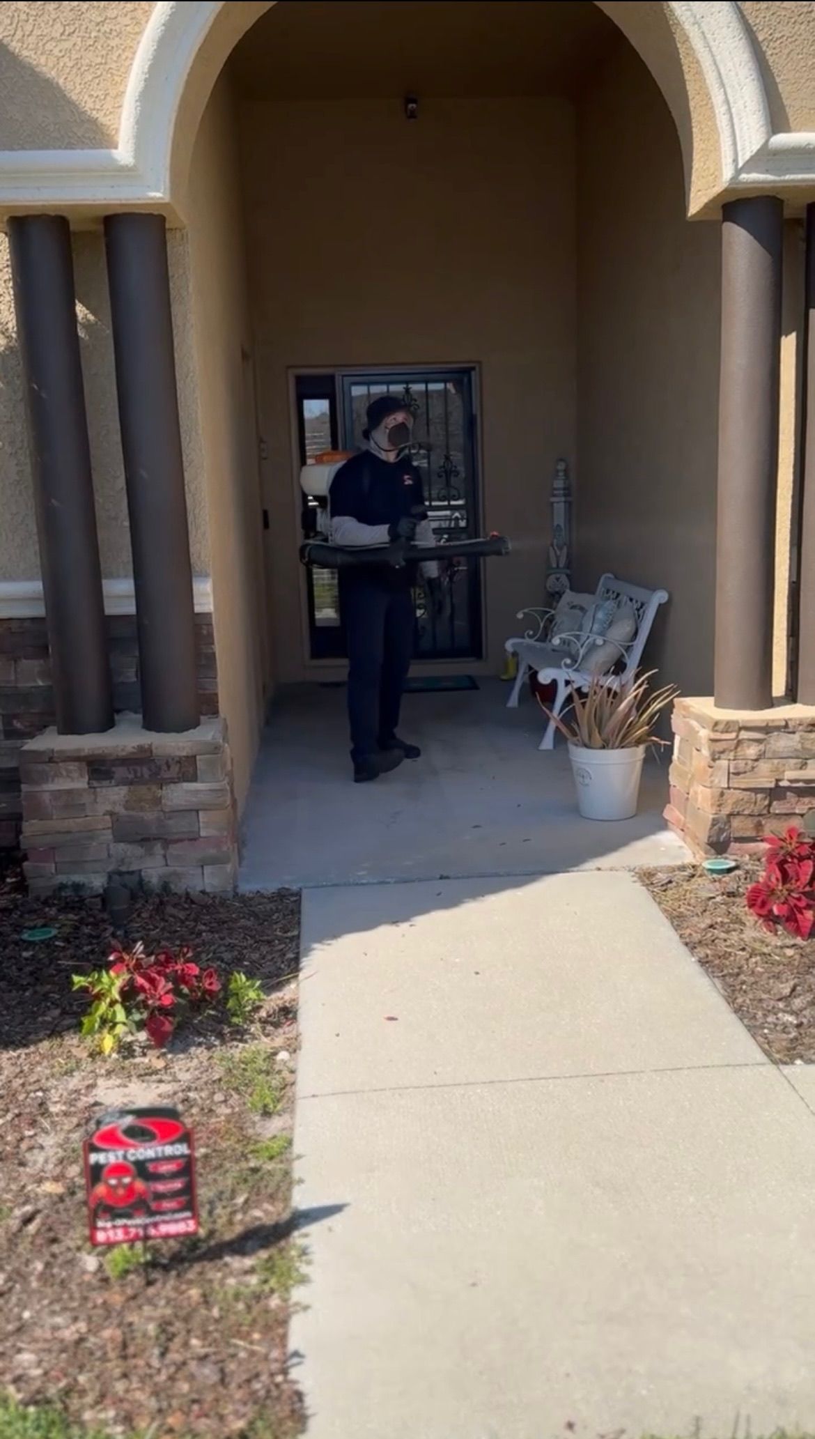 A man is standing in front of a building holding a bag.