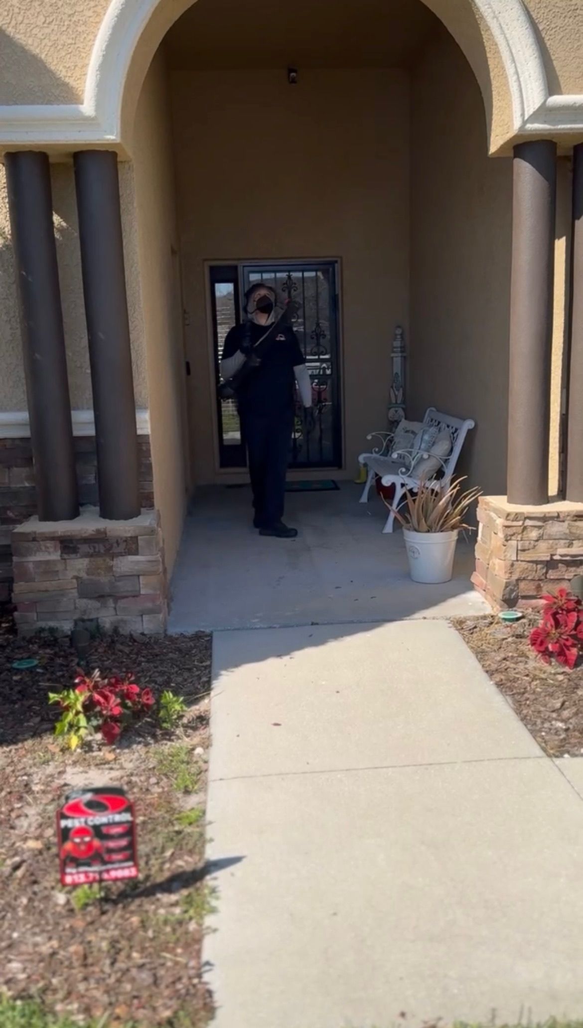 A police officer is standing in the doorway of a house.