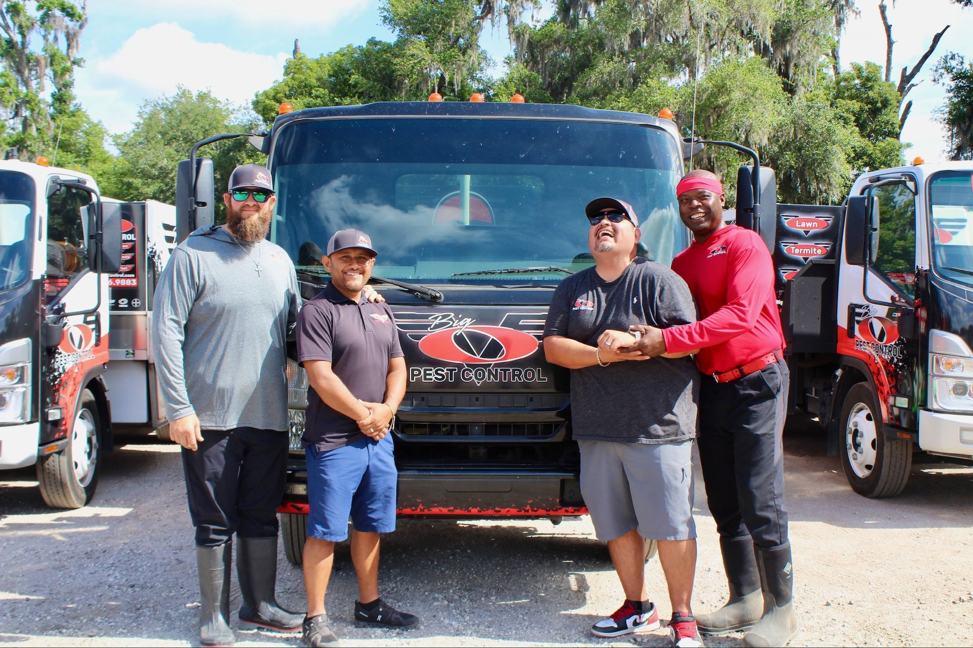 A group of men are standing in front of a truck.