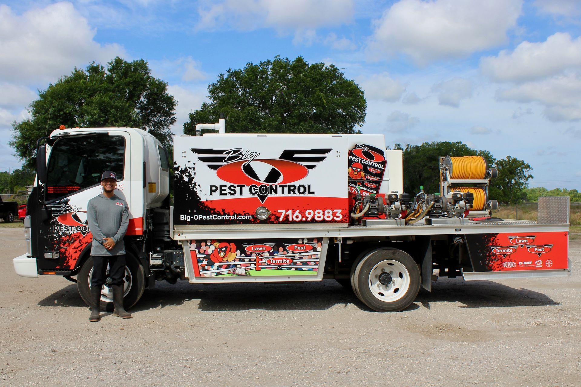 A man is standing in front of a pest control truck.