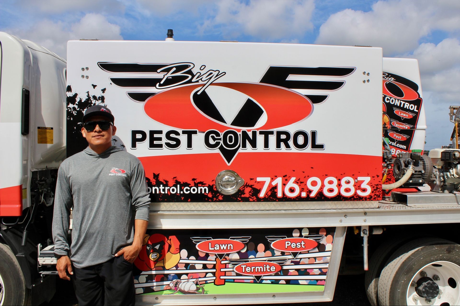 A man is standing in front of a pest control truck.