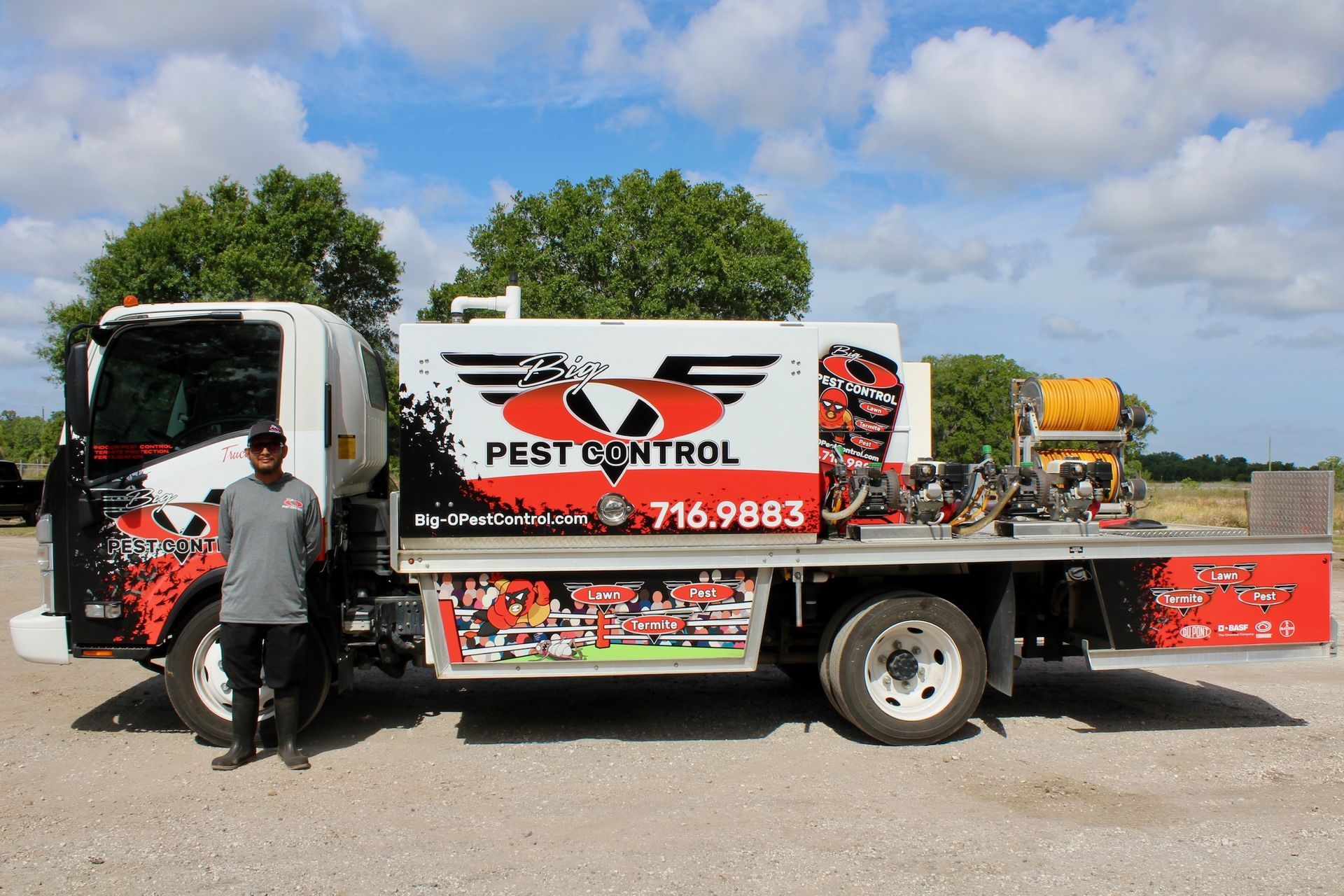 A man is standing in front of a pest control truck