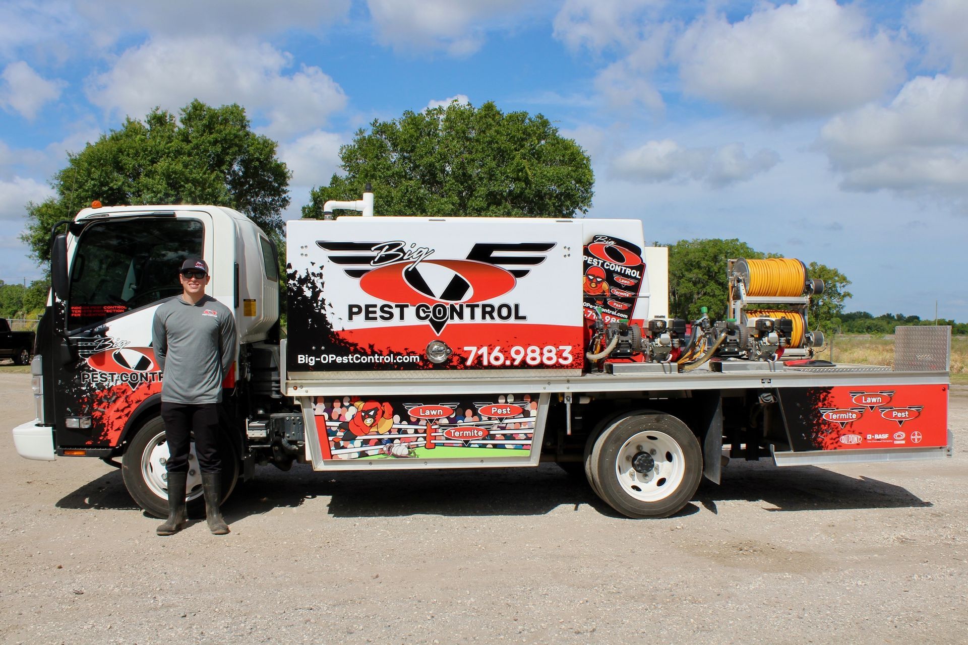 A man is standing in front of a pest control truck