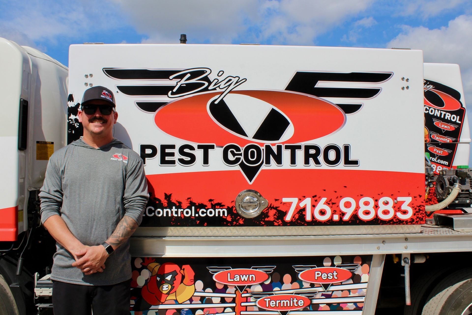 A man is standing in front of a pest control truck.