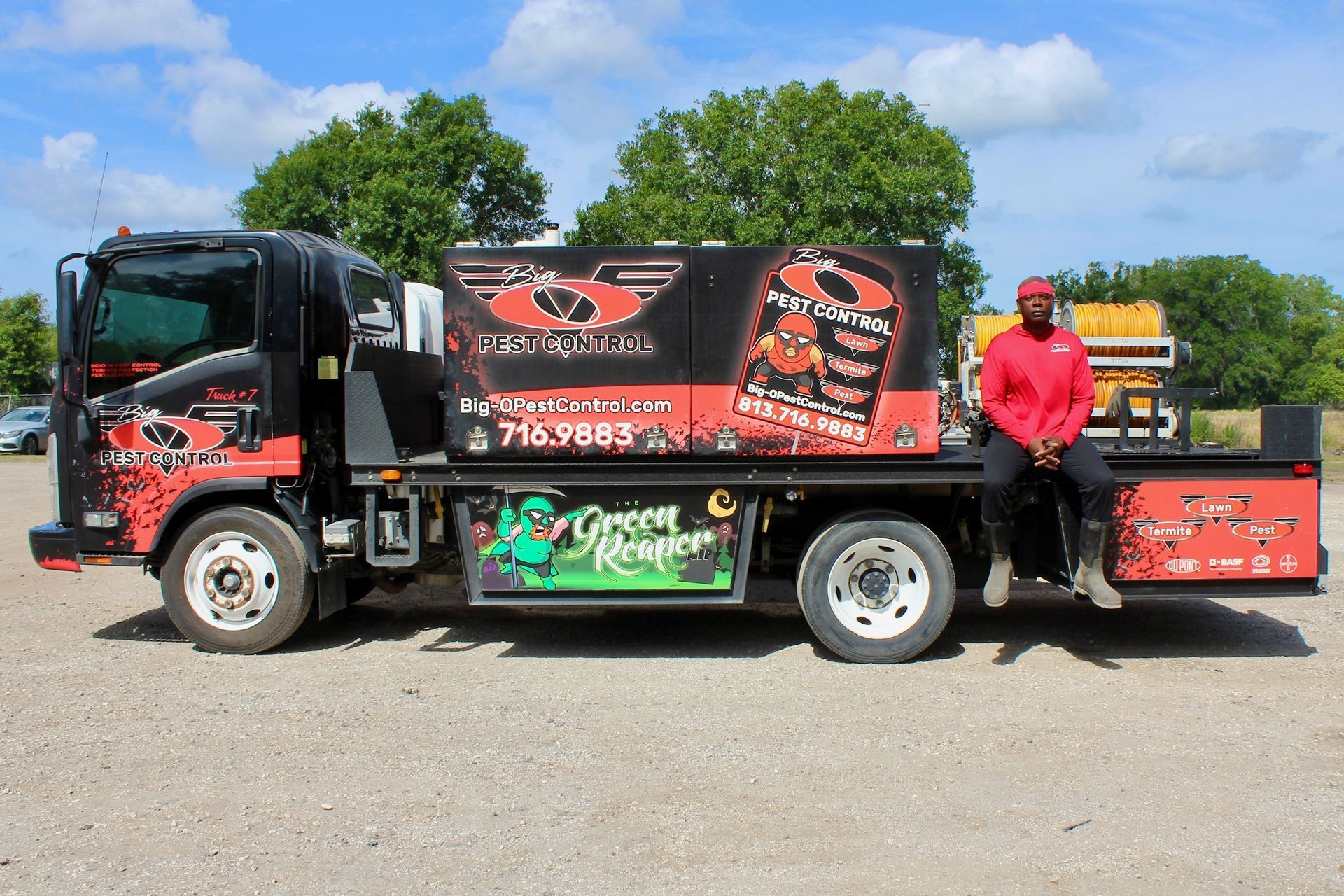 A man is sitting on the back of a truck.