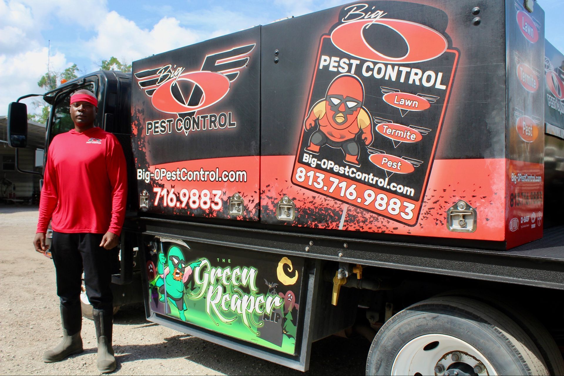 A man is standing next to a pest control truck