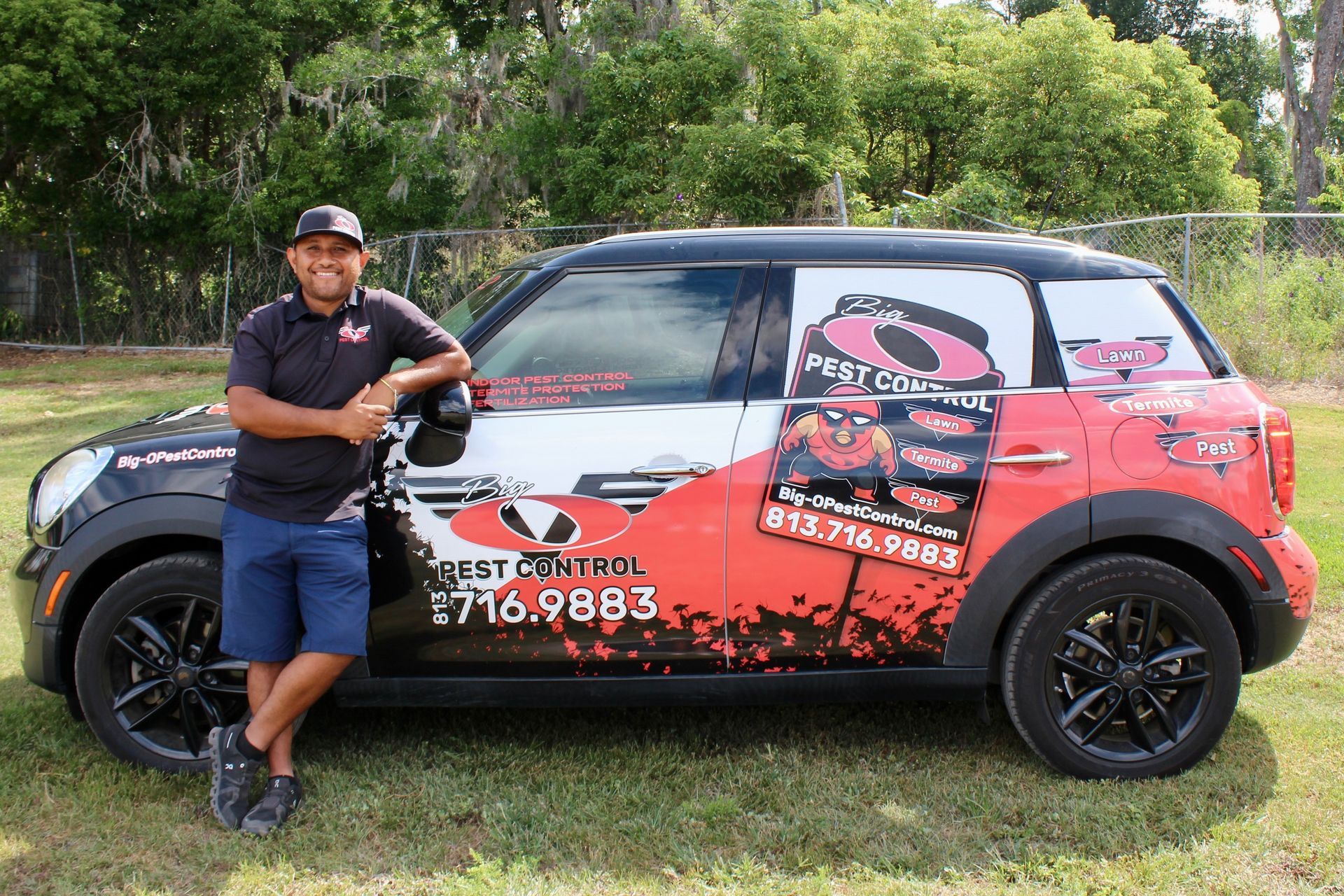A man is standing next to a mini cooper.