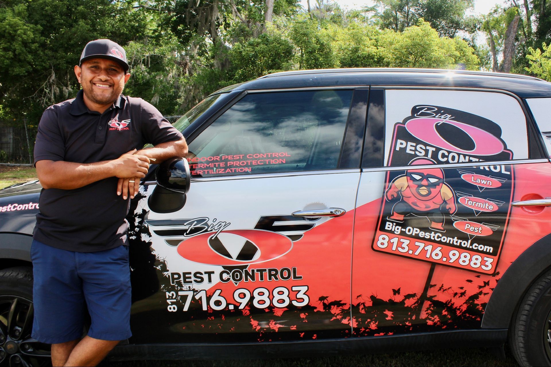 A man is standing in front of a pest control van.