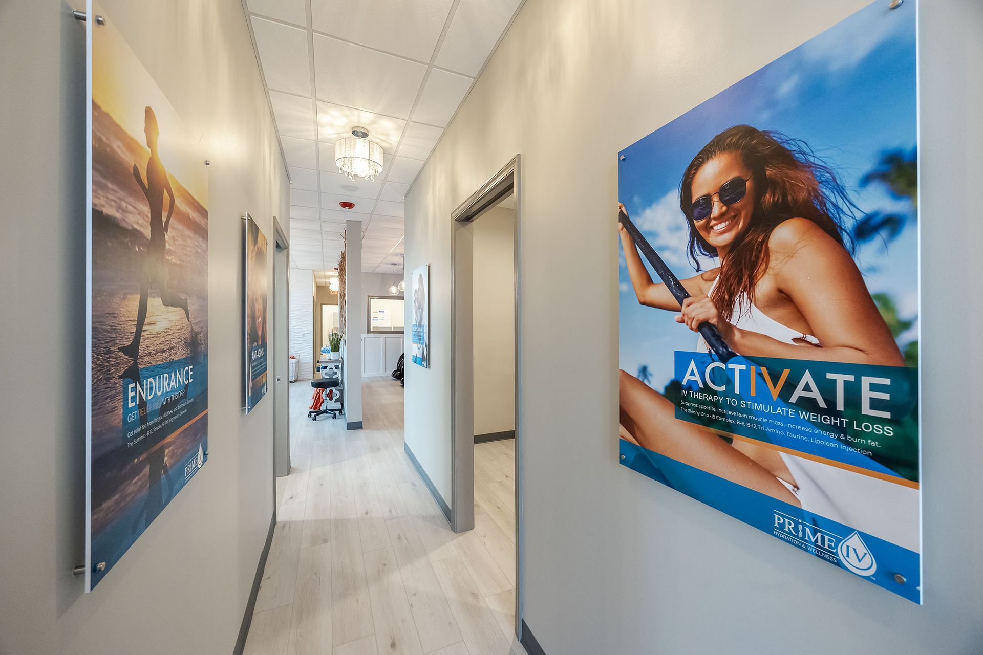 Bright hallway with posters on both walls and an open door at the end.