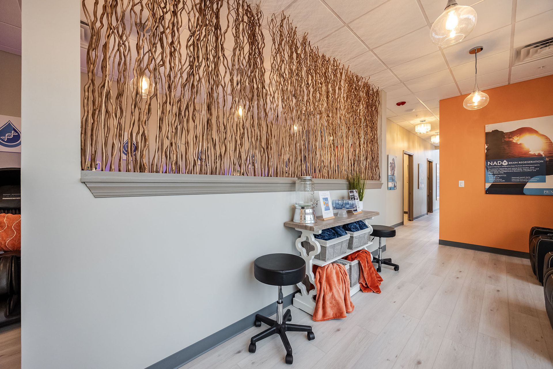 Modern salon interior with styling stations, black stool, orange accent wall, and pendant lights.