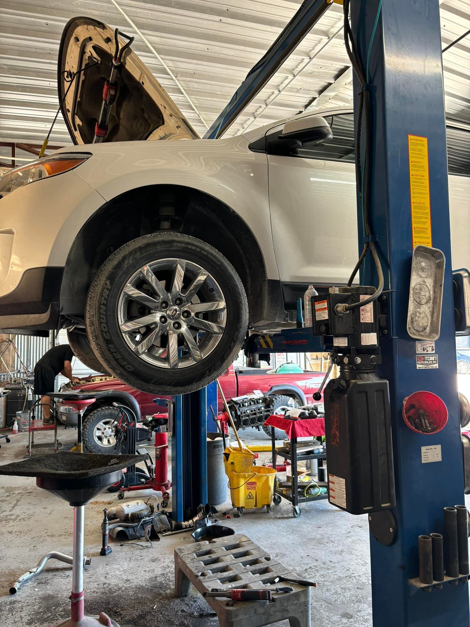 A car is sitting on a lift in a garage.