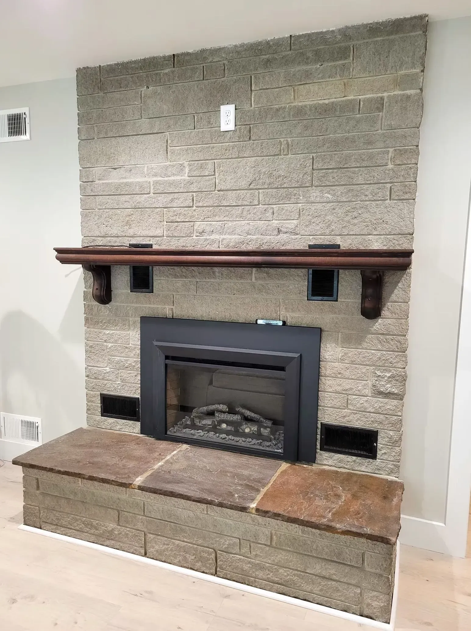 Stone fireplace with a wooden mantel and seating bench.