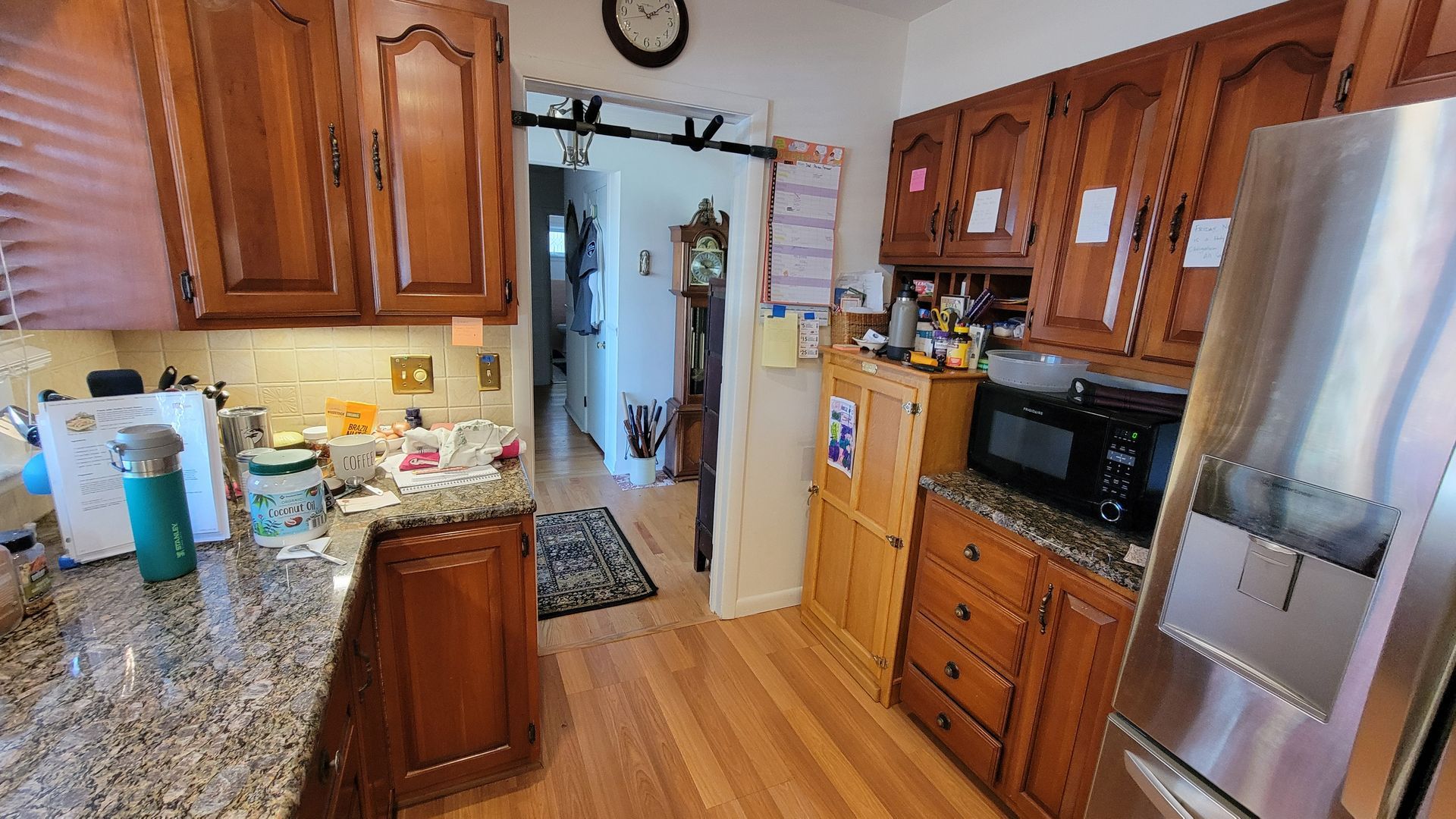 Kitchen with wooden cabinets, granite countertops, and stainless steel refrigerator.
