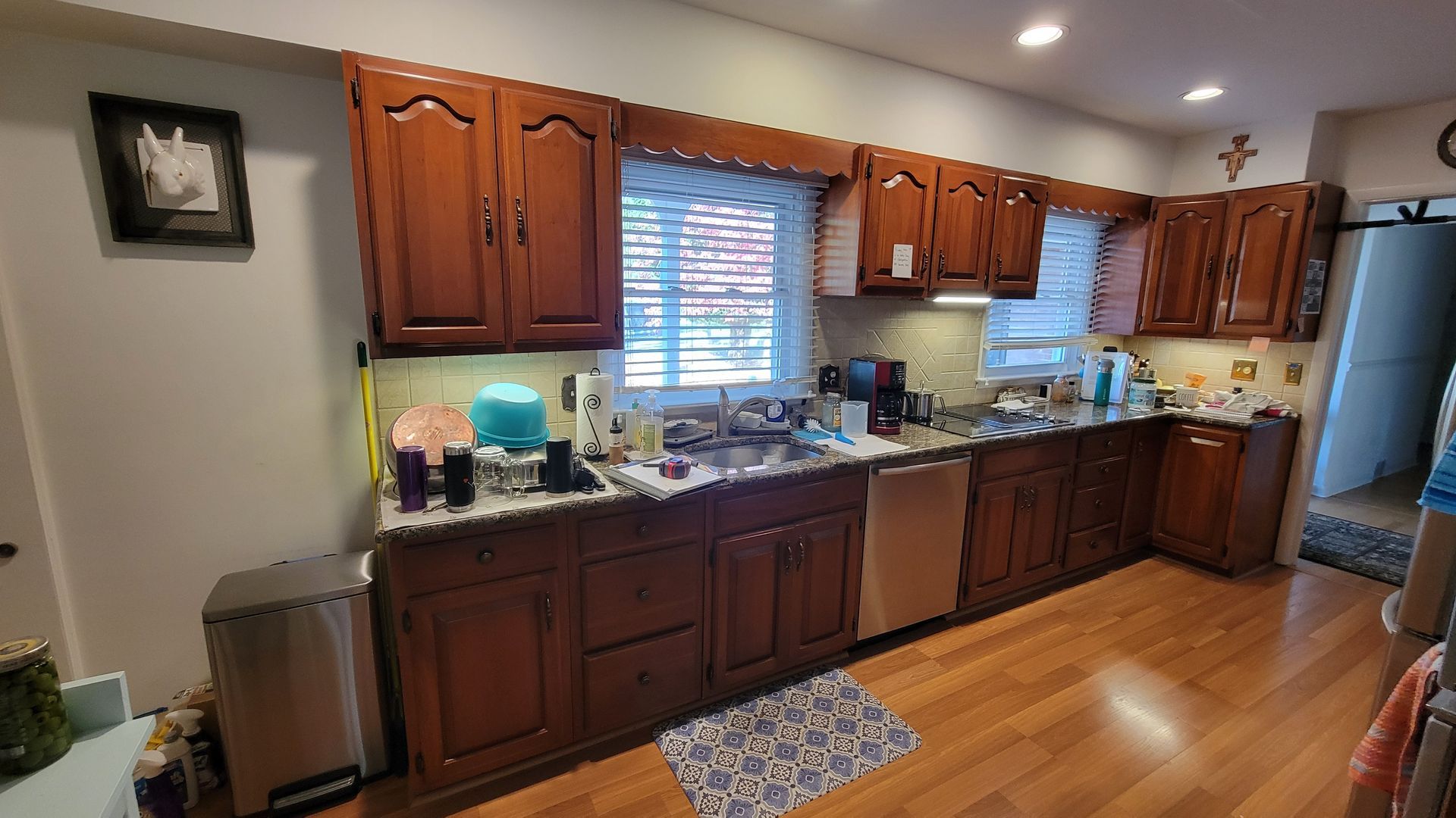Kitchen with dark wood cabinets, stainless steel appliances, and a window above the sink.