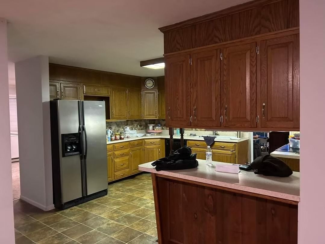 Kitchen with wooden cabinets, stainless steel refrigerator, and counter space.
