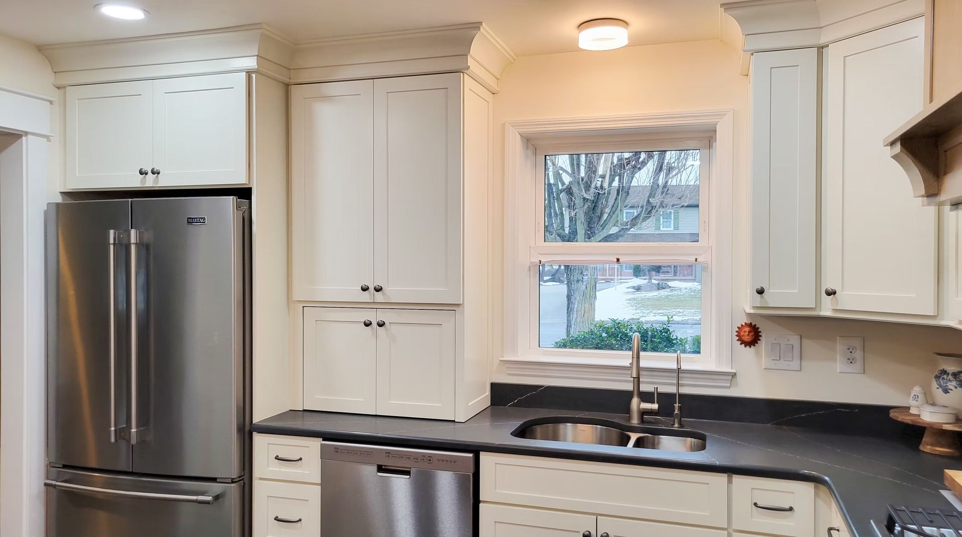 Kitchen with stainless steel appliances and cream cabinets. Window over sink.
