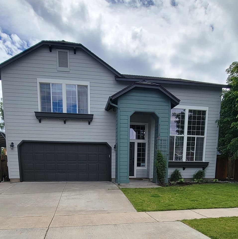 A large white house with a black garage door