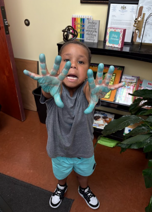 A little boy with blue paint on his hands