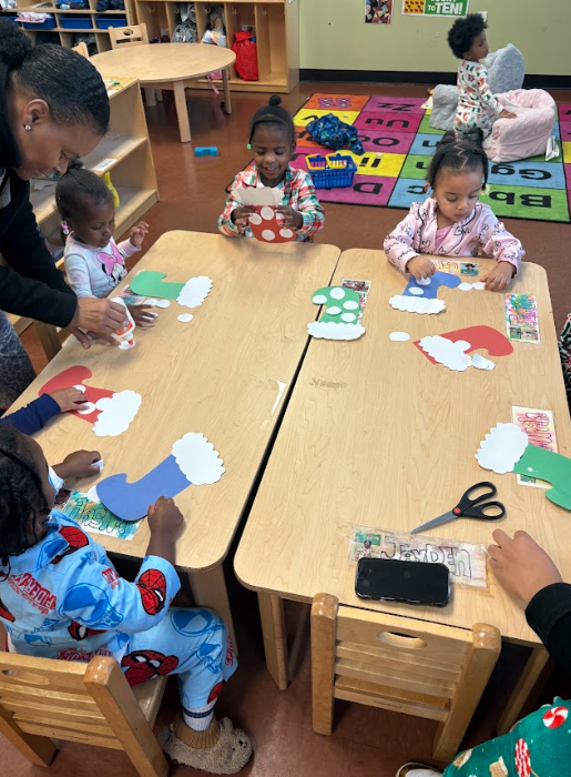 A group of children are sitting at a table making crafts