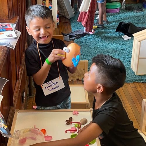 Two young boys are playing with toys in a living room.