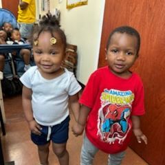 A boy and a girl are holding hands in a room