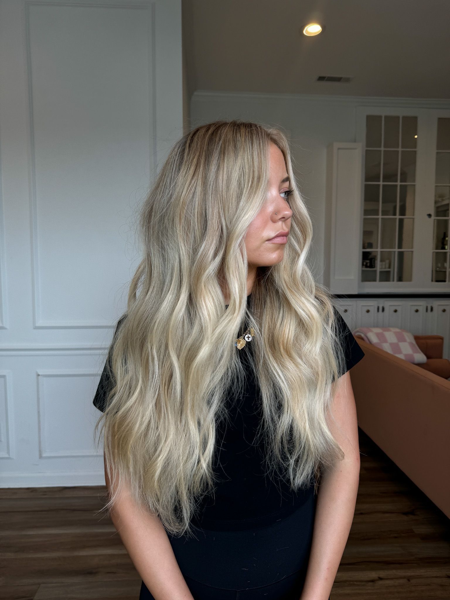 A woman with long blonde hair is standing in a room.