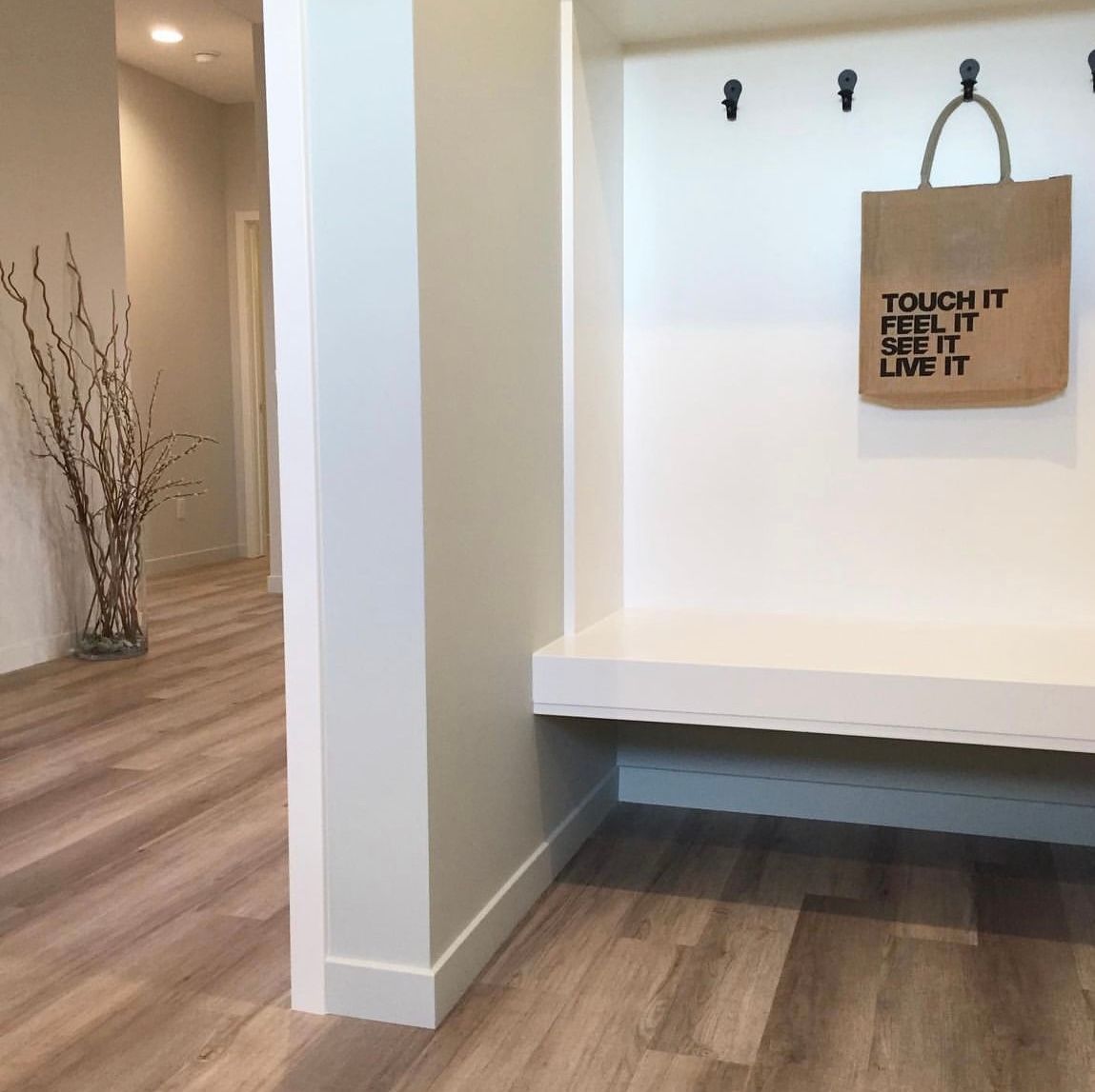 Touch it feel it see it live it bag hanging on white wall