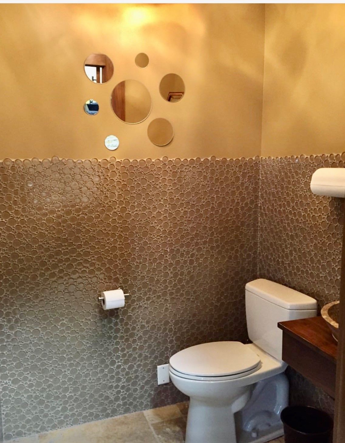 A bathroom with a toilet and mirrors on the wall