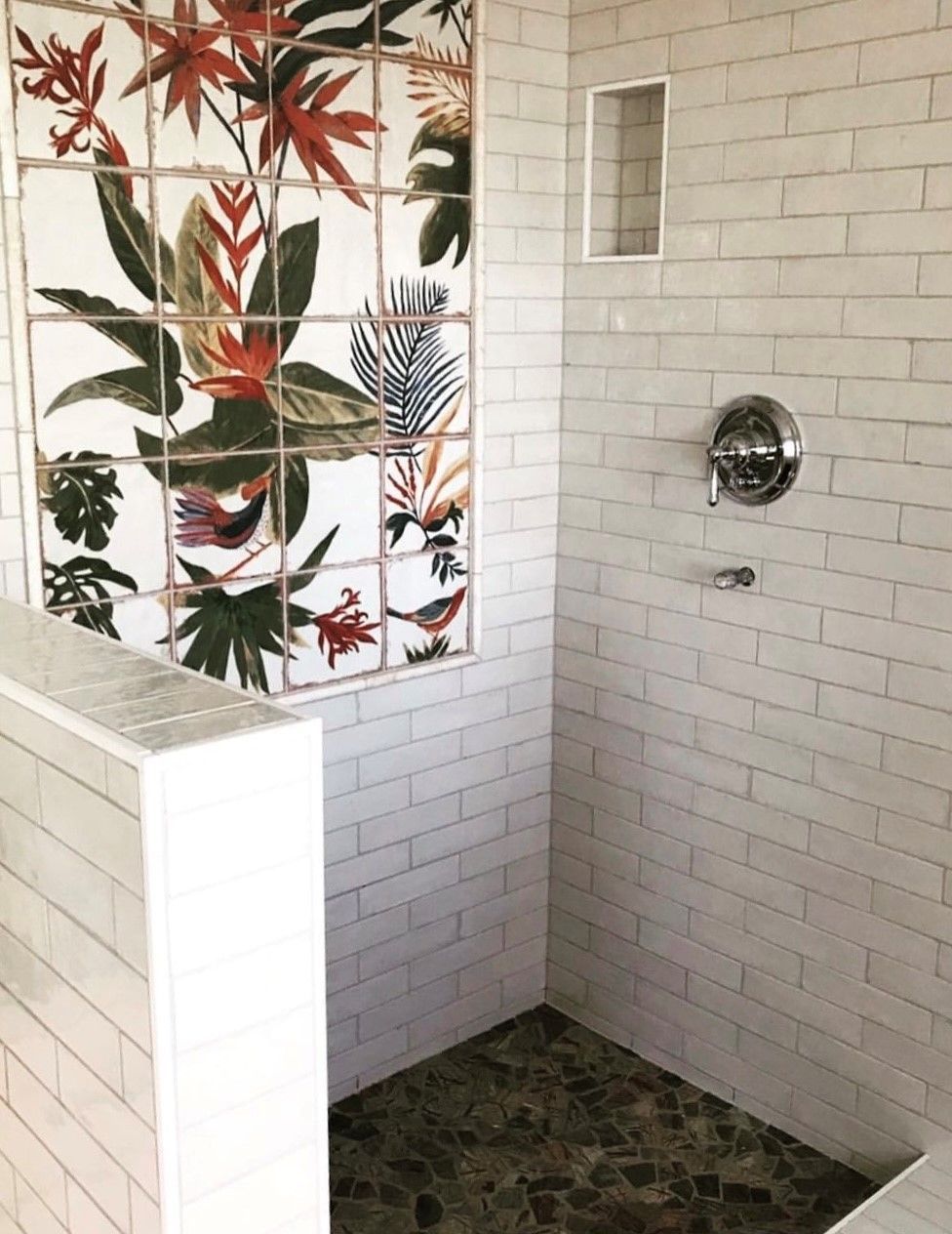 A shower with a picture of flowers on the wall