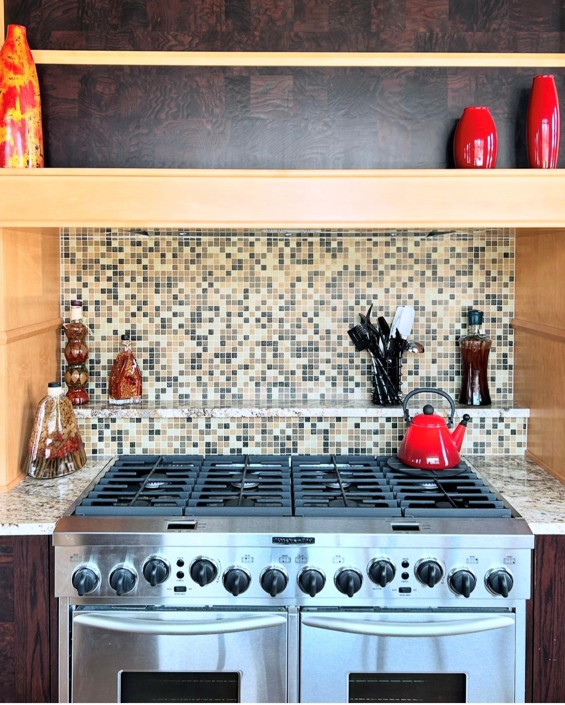 A kitchen with a stove top oven and a shelf above it