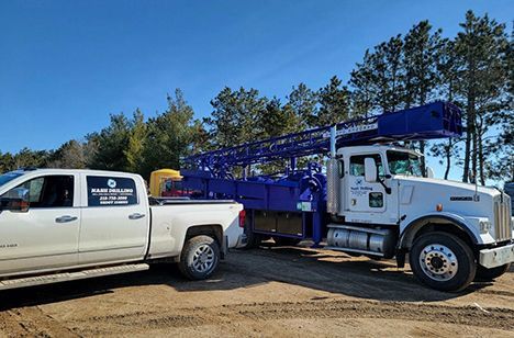 a white truck is parked next to a blue truck .