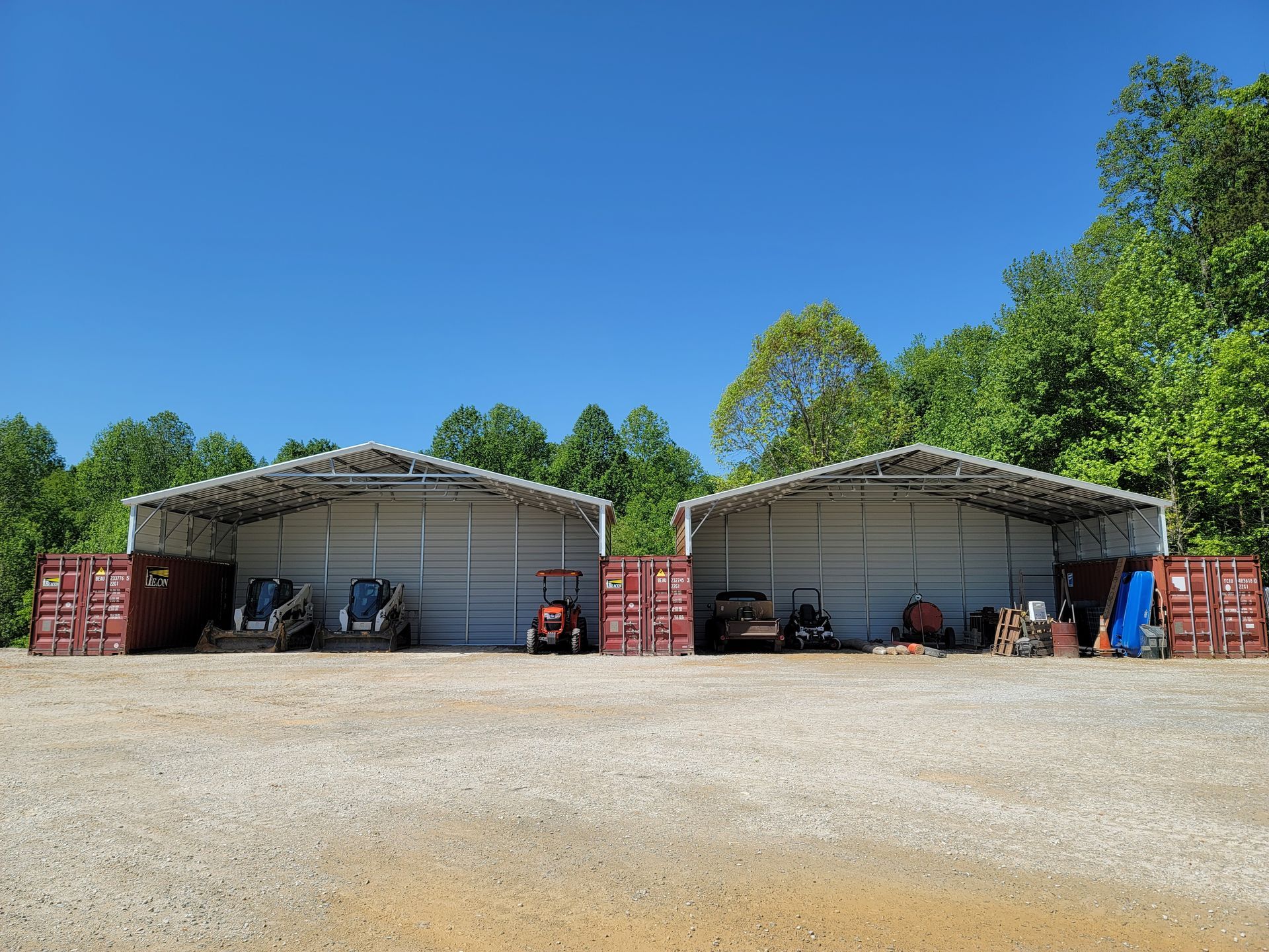 Two metal parking with trucks and equipment