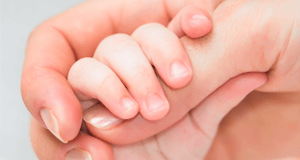 Baby holding woman's hand