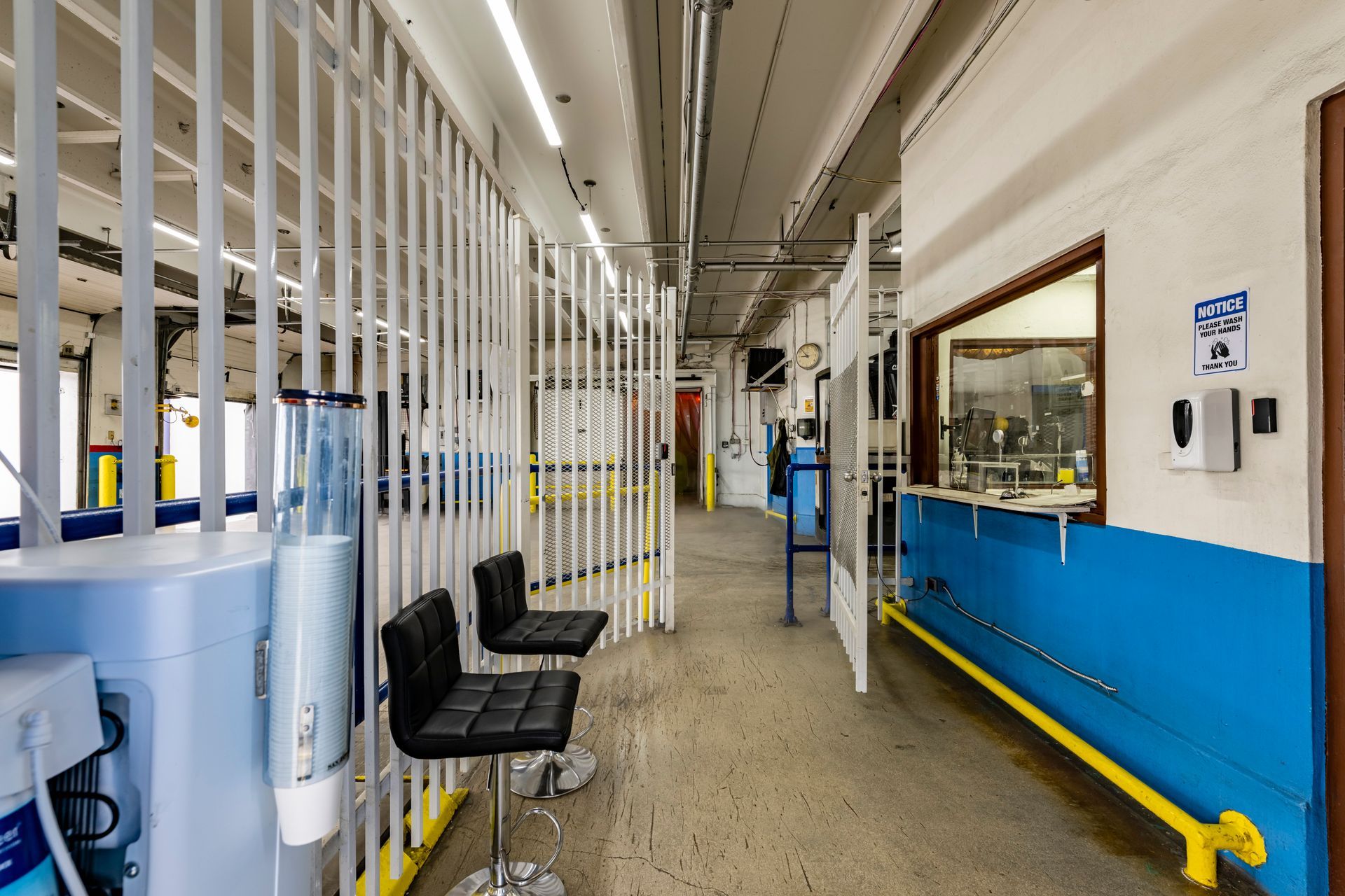 A long hallway with chairs and a counter in a building.