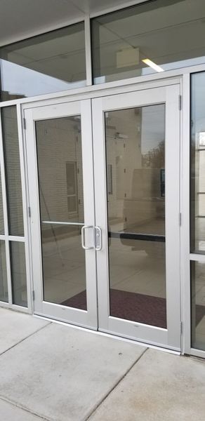 Glass double doors with silver frames, leading into a building.