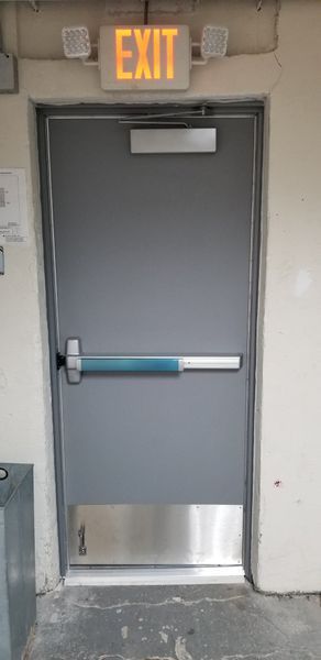 Gray door with a silver push bar and EXIT sign above.