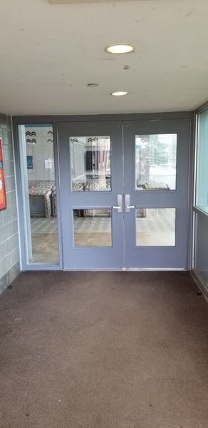 Gray double doors with glass panels; entry to a building.