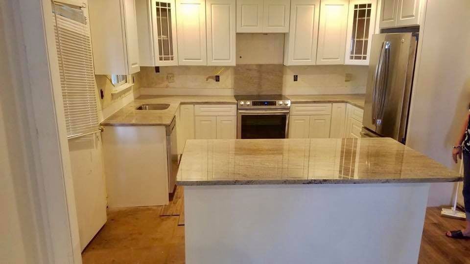 Bright white kitchen with island, beige countertops, and stainless steel appliances