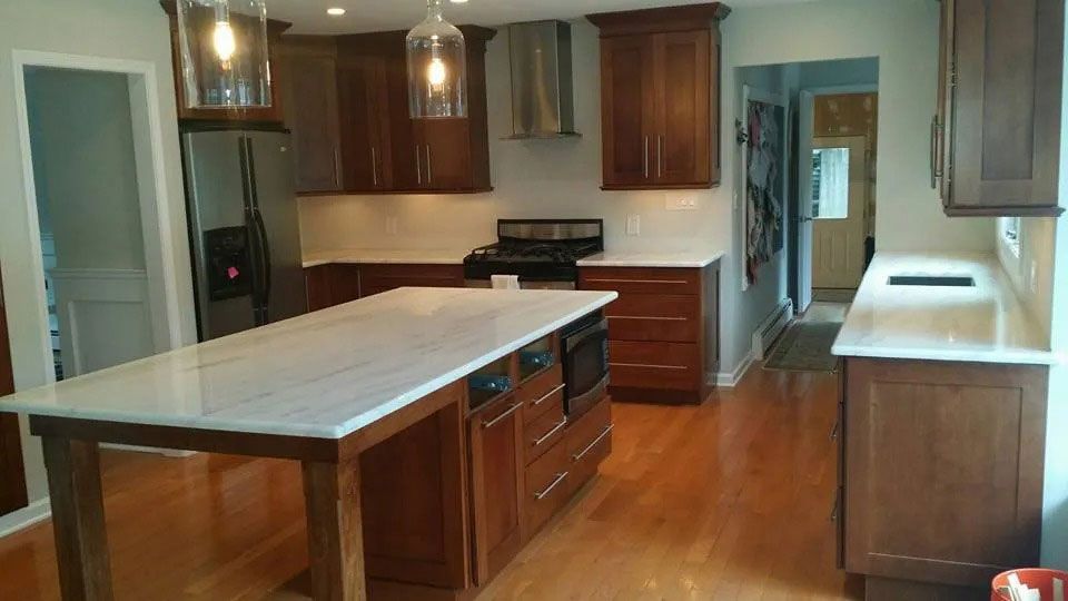 Modern kitchen with a large island, wood cabinets, and hardwood floors
