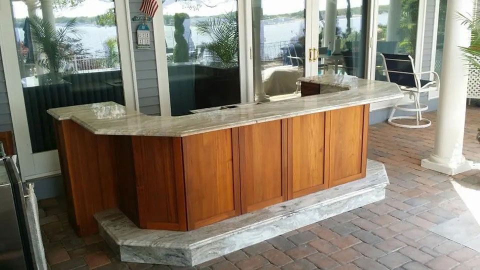 Wood-paneled reception desk with marble countertop beside glass windows and a brick walkway