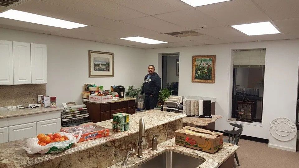 Cafeteria room with buffet tables, food trays, and a person standing near the back wall.