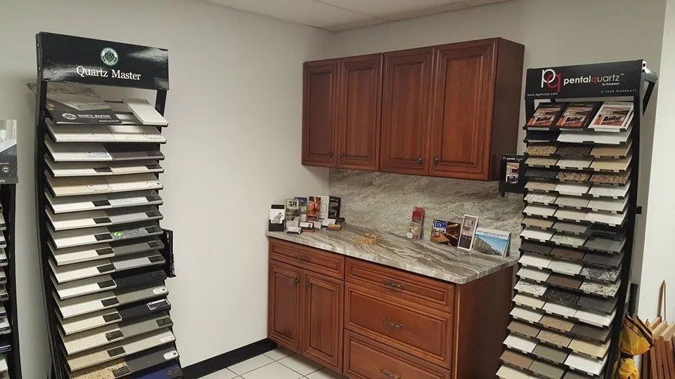 Countertop with wood cabinets and granite sample racks in a flooring showroom.