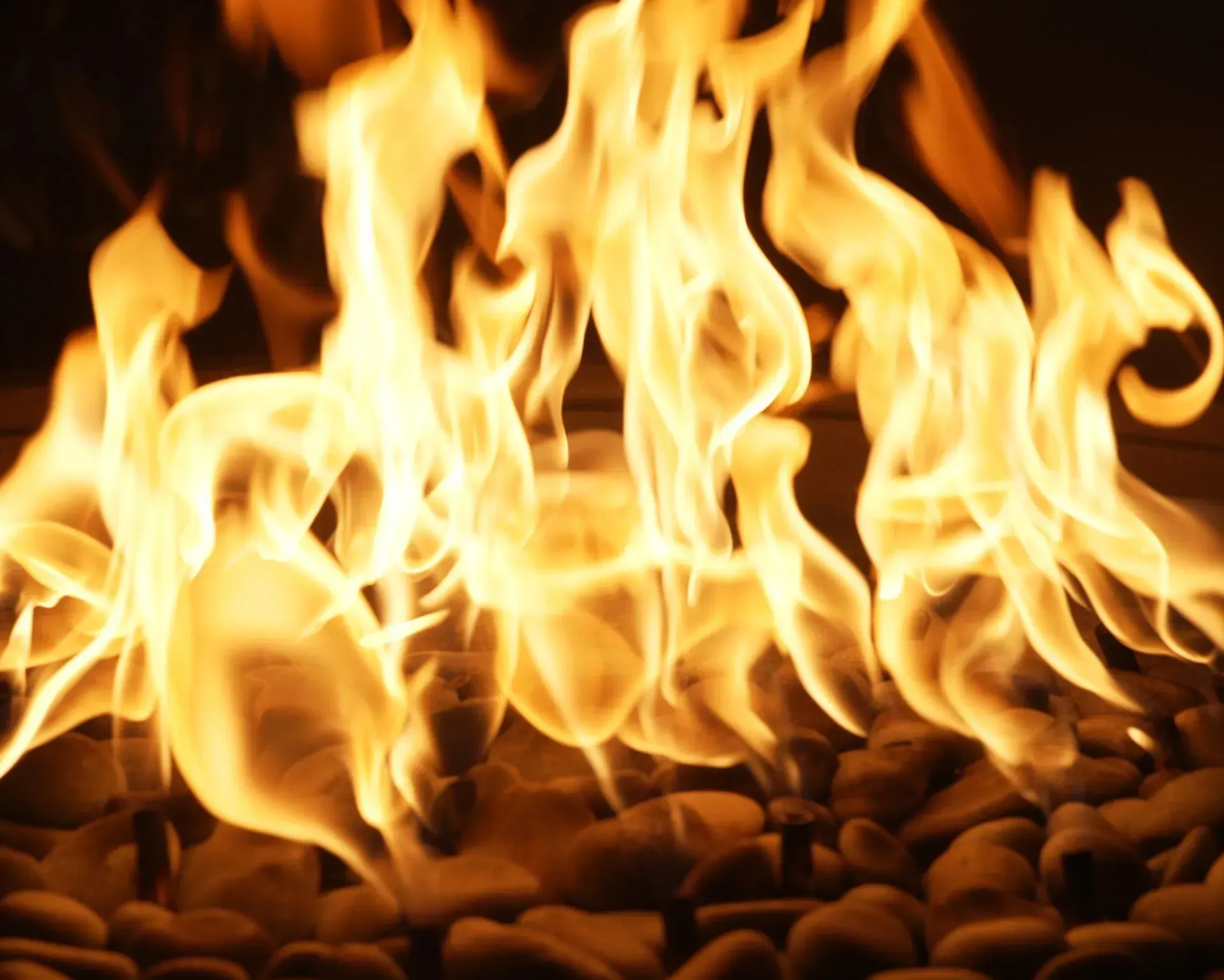 Flames of orange and yellow burning over brown stones