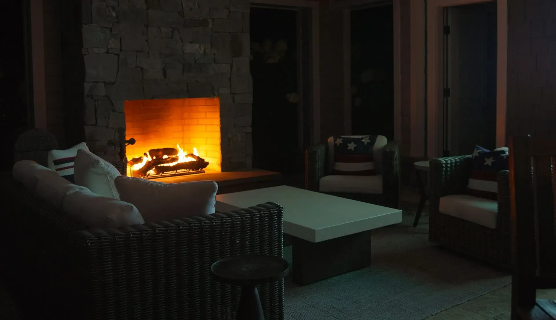Cozy outdoor seating area with lit fireplace
