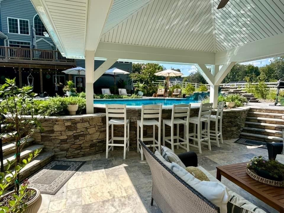 A patio with a couch , chairs , a table and a pool