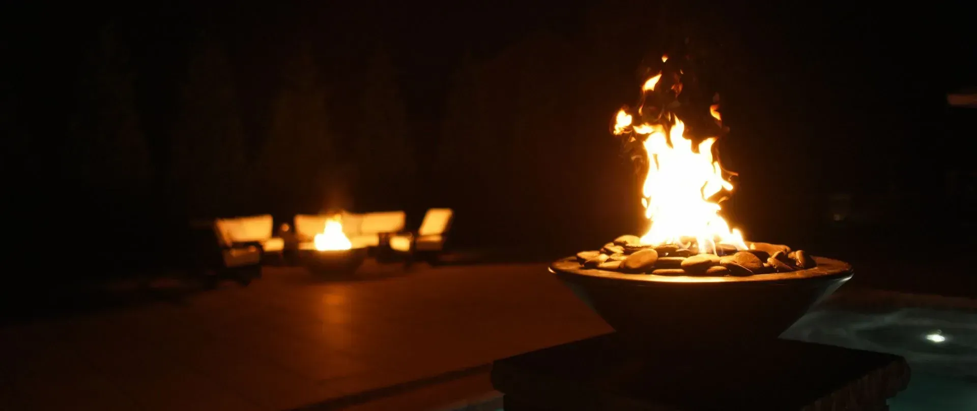 A fire pit burns brightly at night