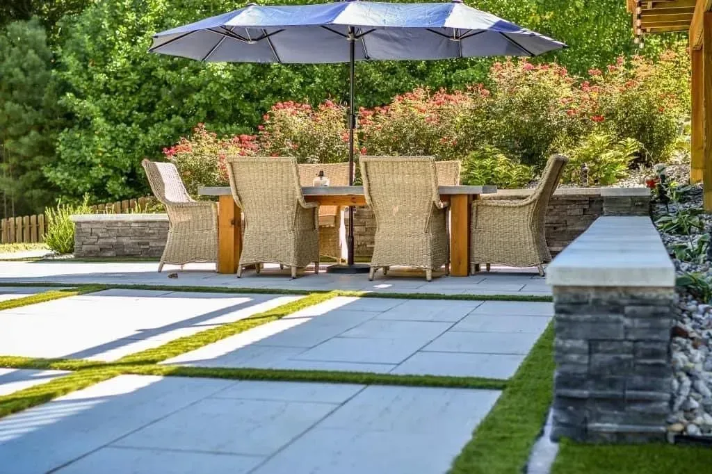 a patio with a table and chairs under an umbrella