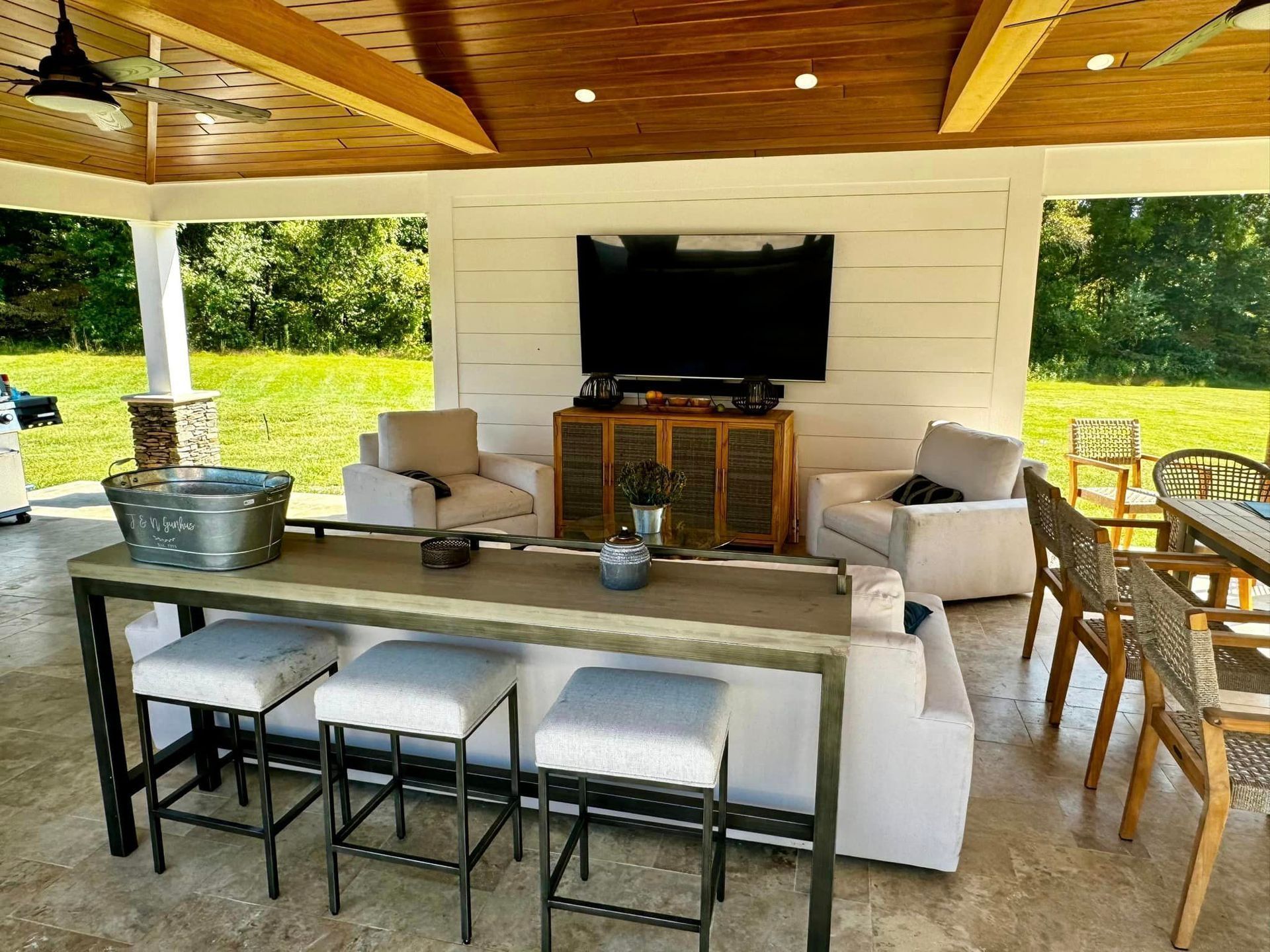 A living room with a table , chairs , and a flat screen tv.