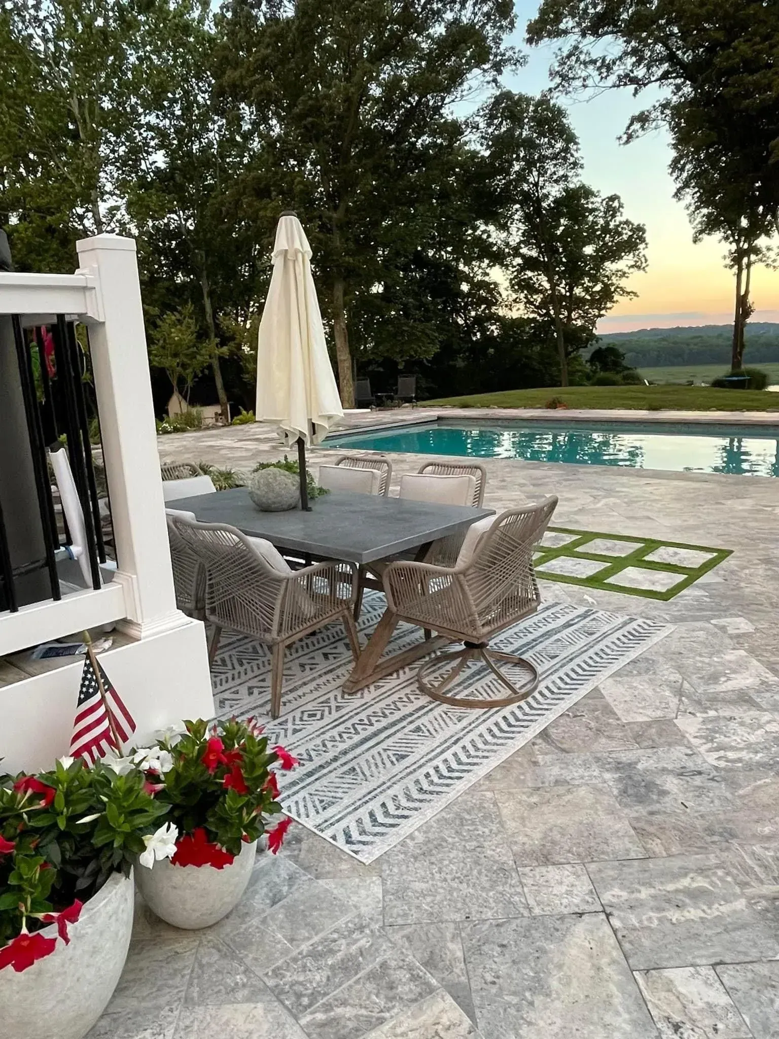 a patio with a table and chairs next to a pool